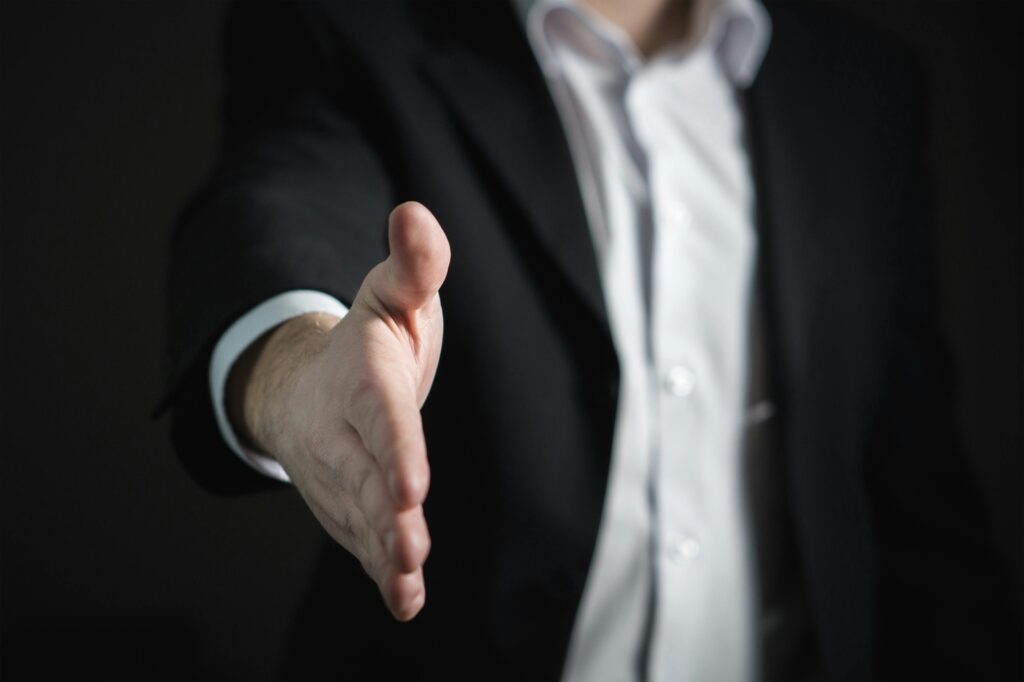 pexels-photo-327540-327540-2 Close-up of a businessman extending hand for a handshake, symbolizing agreement and partnership.
