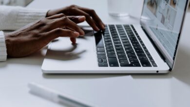 Hands typing on a sleek laptop keyboard, illustrating modern technology in use.