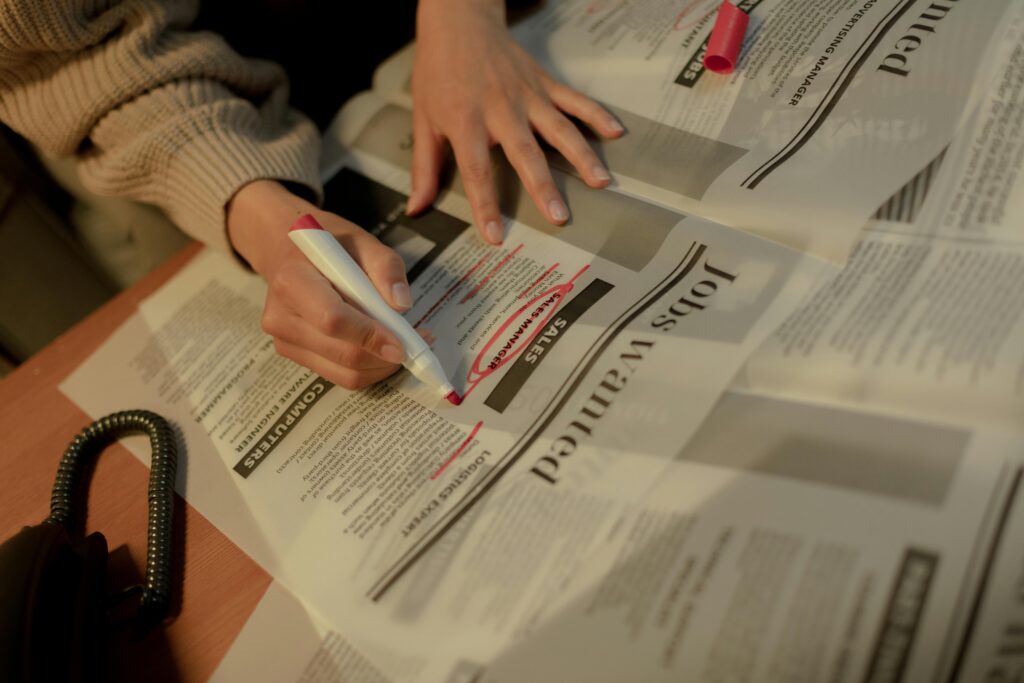 pexels-photo-9832718-9832718 An adult woman highlights job ads in a newspaper, focusing on employment opportunities.